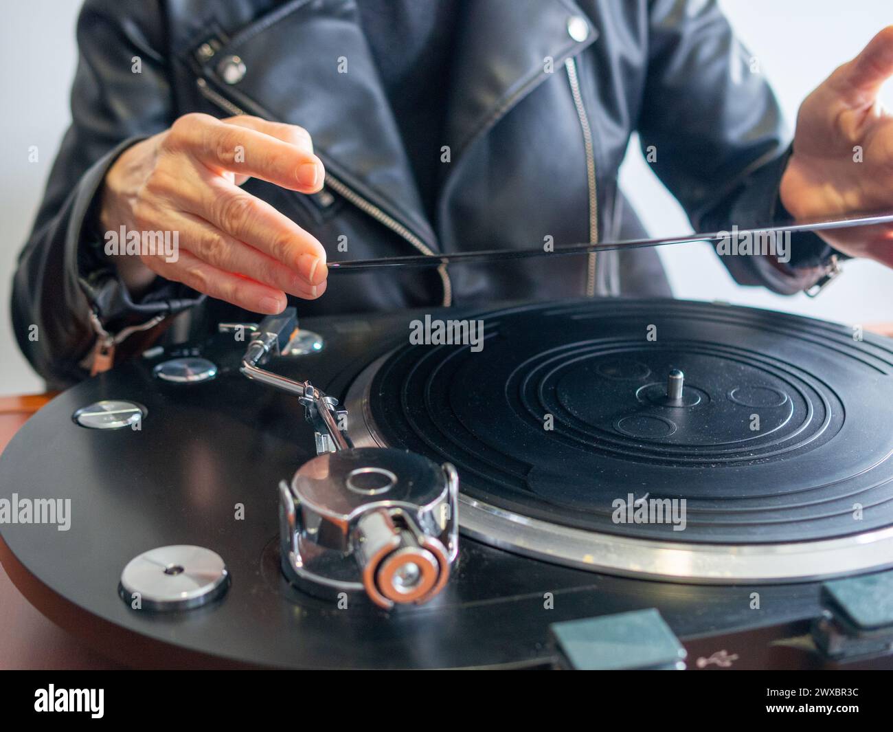 An unrecognizible lady holding a vinyl record ready to play it on her turntable Stock Photo
