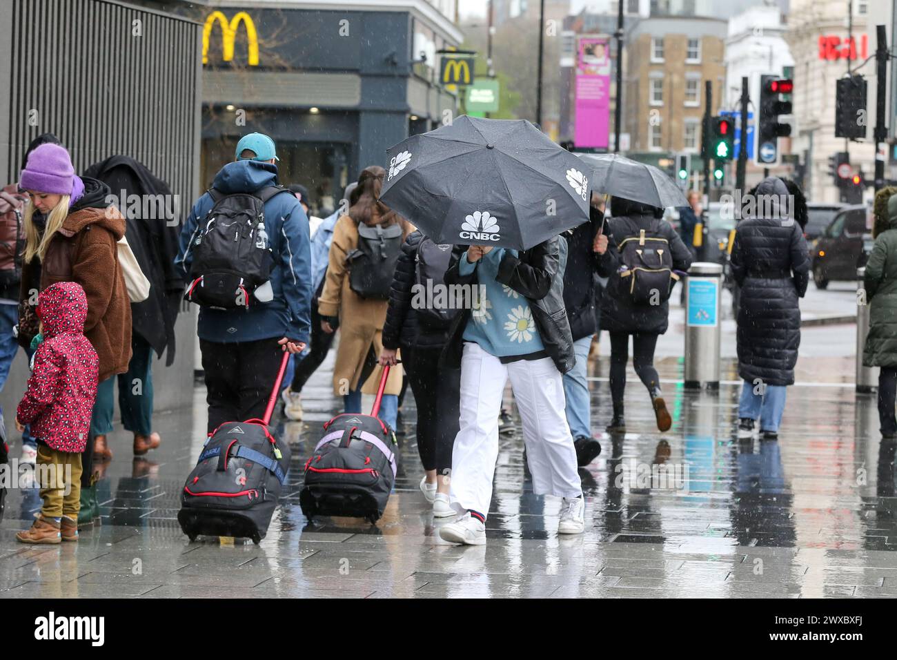 A Woman Shelters Under An Umbrella During Wet Weather In Central London A woman shelters under an umbrella during wet weather in central london