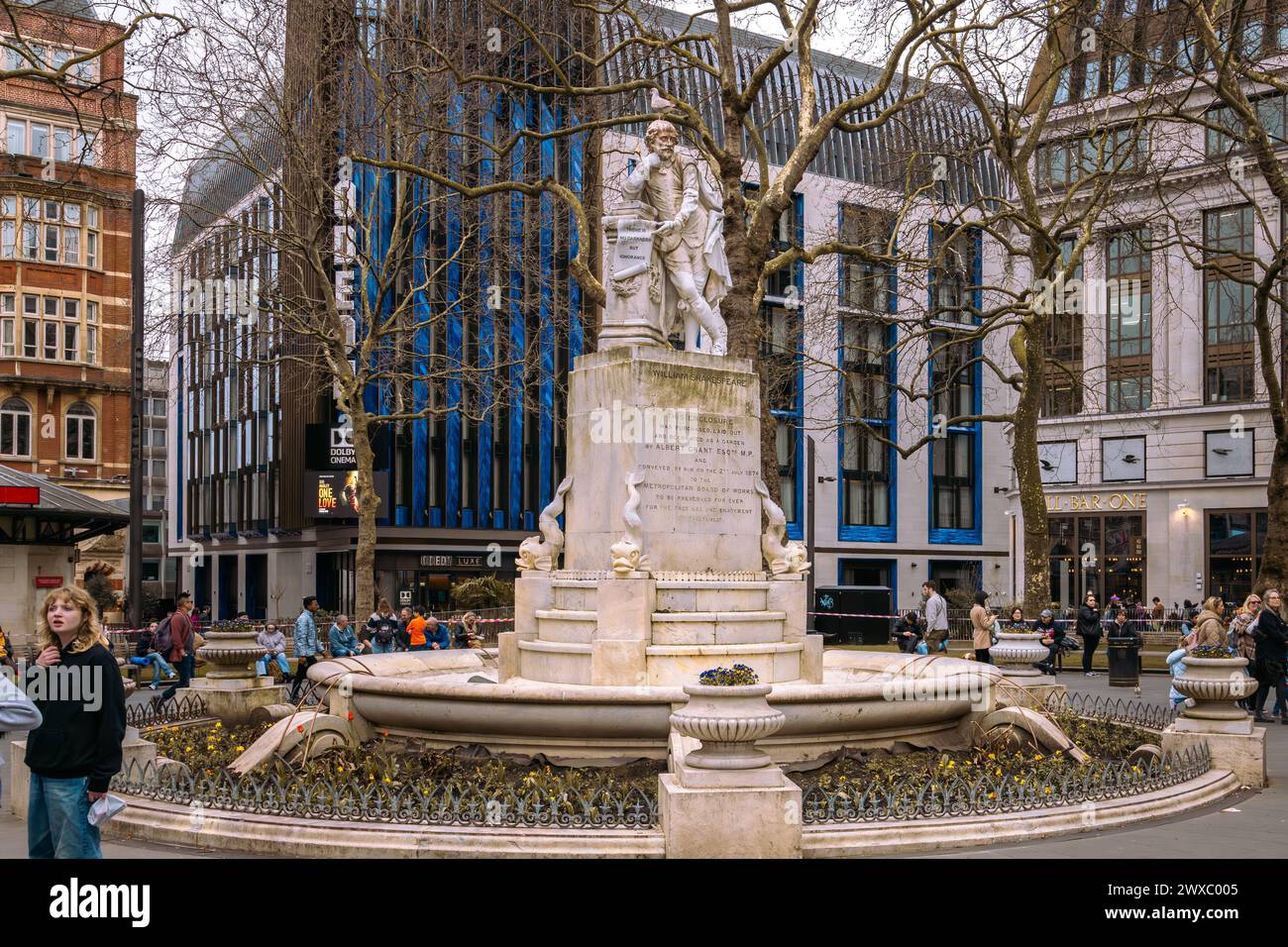 A statue of William Shakespeare has formed the centrepiece of Leicester Square Gardens in London since 1874. The iconic Odeon Luxe cinema to the rear. Stock Photo
