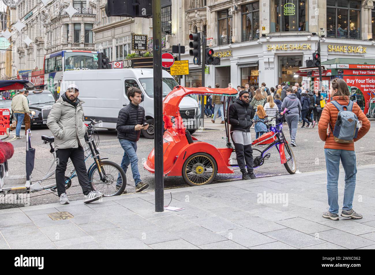 Pedicab or rickshaw rider parks on yellow lines while waiting for his next customer. The Pedicabs London Bill will regulate fares and enhance safety. Stock Photo