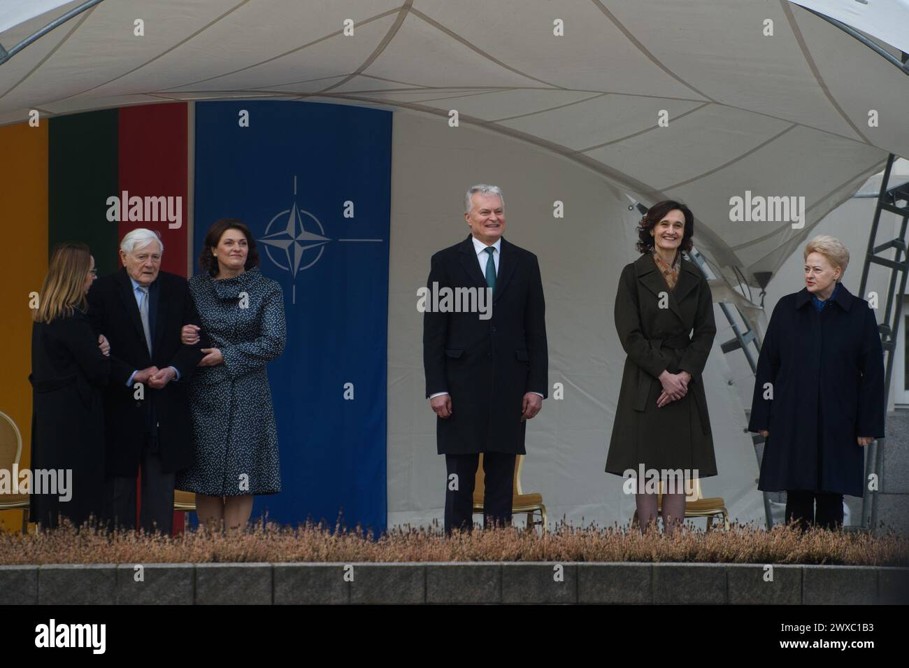 President of Lithuania Gitanas Nauseda (center), first lady Diana Diana Nausediene (3rd left), speaker of the Lithuanian Seimas Viktorija Cmilyte-Nielsen (2nd right) and former Lithuanian presidents Valdas Adamkus (2nd left) and Dalia Grybauskaite (1st right) during the 20th anniversary of Lithuania's NATO membership celebration. Solemn ceremony to mark Lithuania's NATO membership 20th anniversary took place at the S. Daukantas Square, in front of the Presidential Palace in Vilnius, on March 29, 2024. 20 years ago Lithuania became a full-fledged member of NATO. Stock Photo