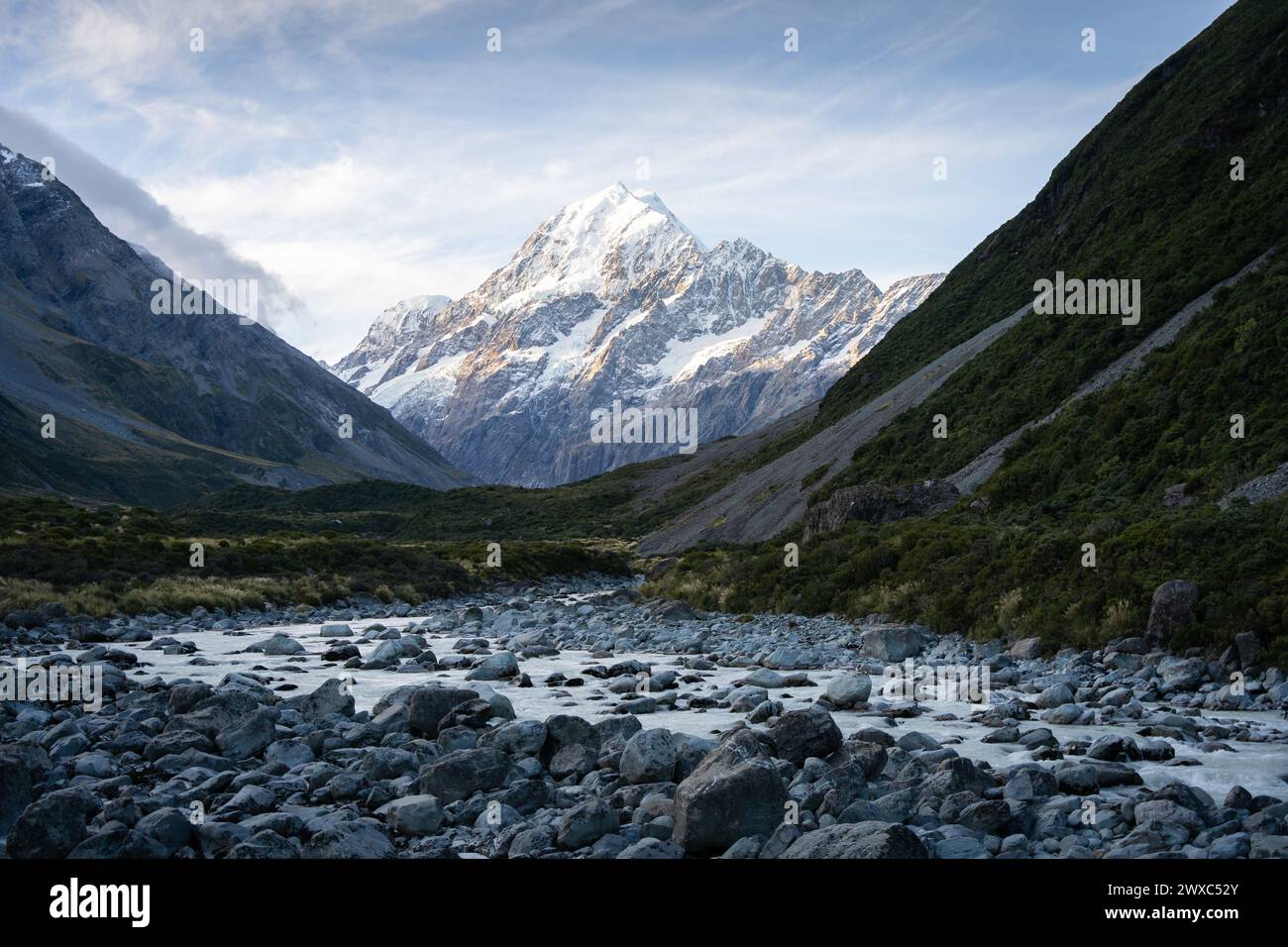 Alpine valley with glacial river flowing through and prominent peak in backdrop during sunset,Aoraki. Stock Photo