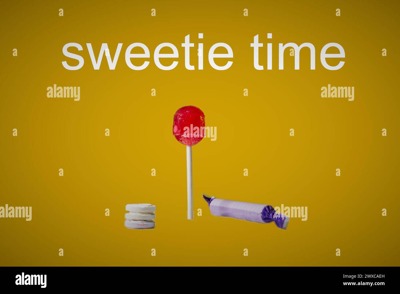 Sweets on a yellow background with text above saying sweetie time. Stock Photo