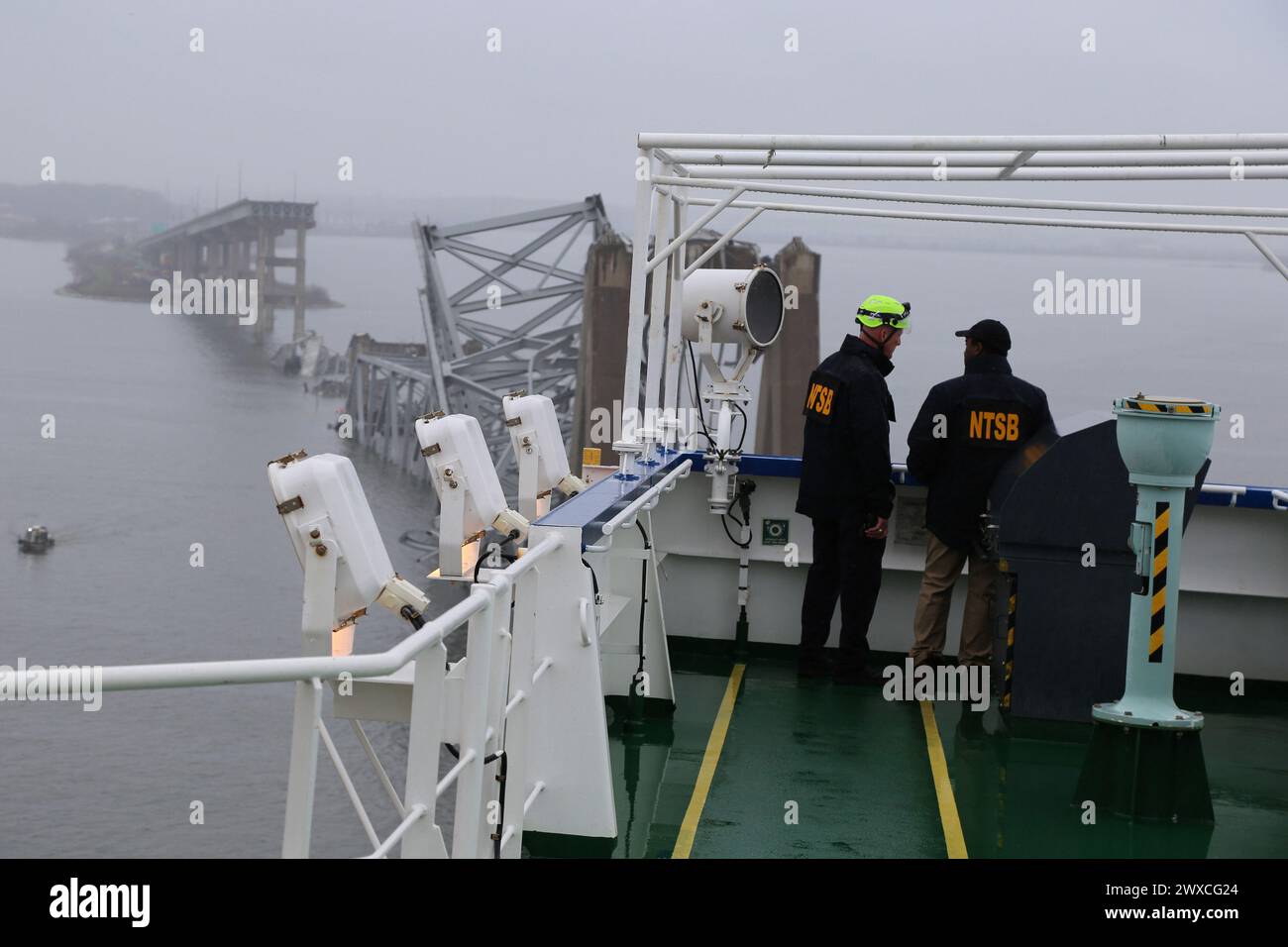 Baltimore, United States. 27th Mar, 2024. NTSB investigators on the cargo vessel Dali on Wednesday, March 27, 2024, which struck and collapsed the Francis Scott Key Bridge in Baltimore, Maryland, in the early hours of March 26, 2024. A portion of the collapsed bridge remains across the vessel's bow, and the vessel remains in the vicinity of the bridge pier. No pollution has been reported at this time. Photo by Peter Knudson/NTSB/UPI Credit: UPI/Alamy Live News Stock Photo