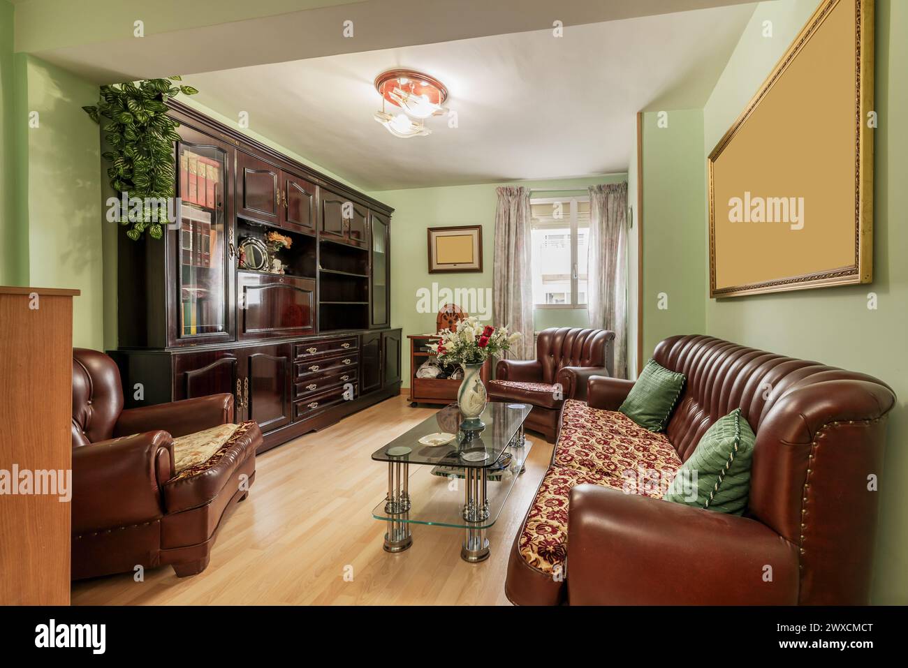 living room of a house furnished with old furniture and a sofa upholstered in skay brown Stock Photo