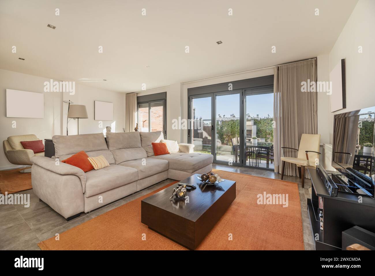 Living room on the ground floor of a single-family house with access to a rear plot with a complete barbecue Stock Photo