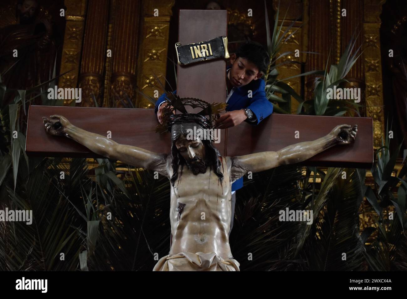 Tunja, Colombia. 29th Mar, 2024. A kid fixes the statue of Jesus Christ on the corss during the celebrations of the Good Friday in Tunja, Colombia on March 29, 2024. Photo by: Cristian Bayona/Long Visual Press Credit: Long Visual Press/Alamy Live News Stock Photo