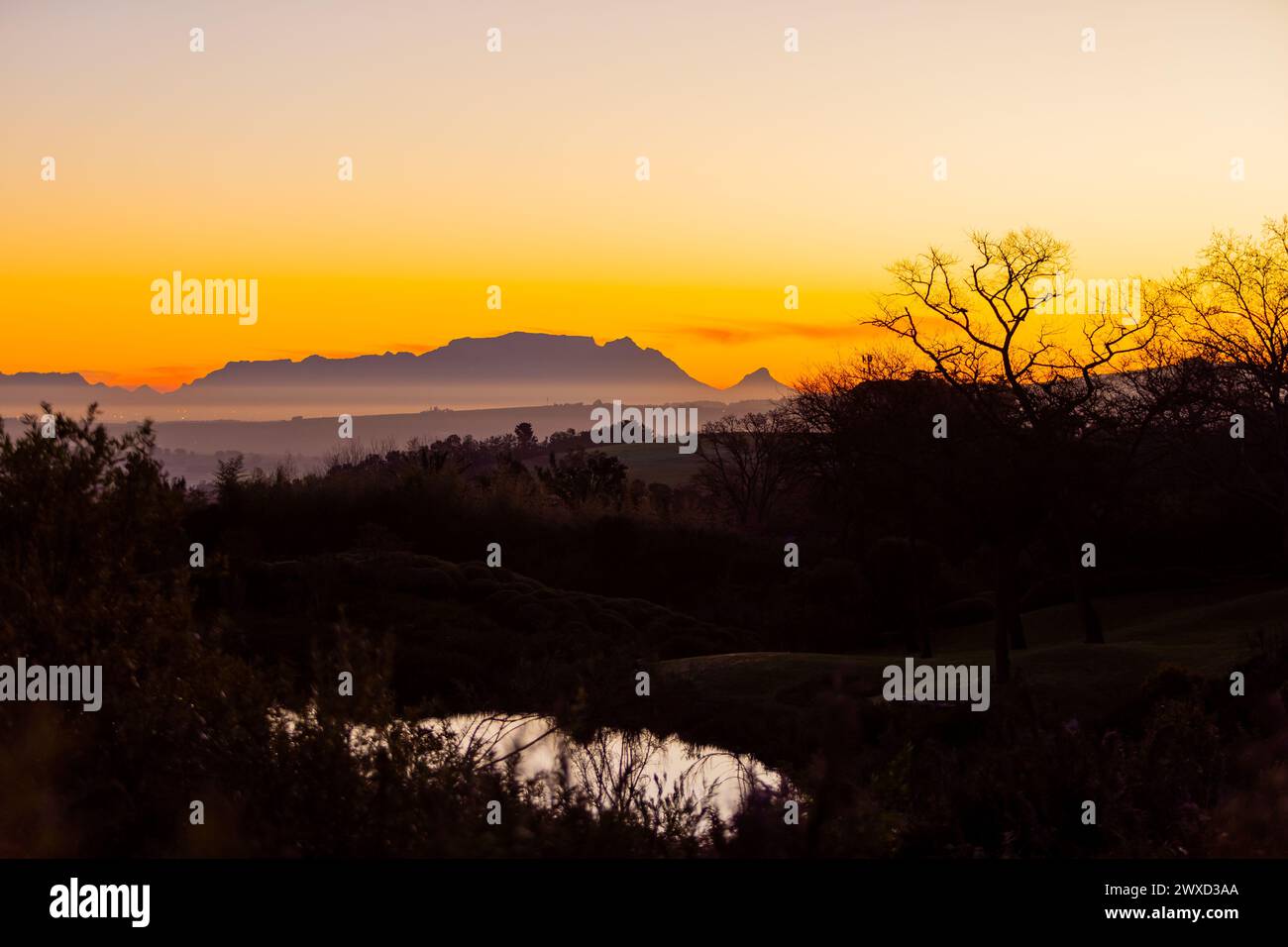 Silhouette of Table Mountain against a dusk sunset sky in Cape Town, South Africa Stock Photo