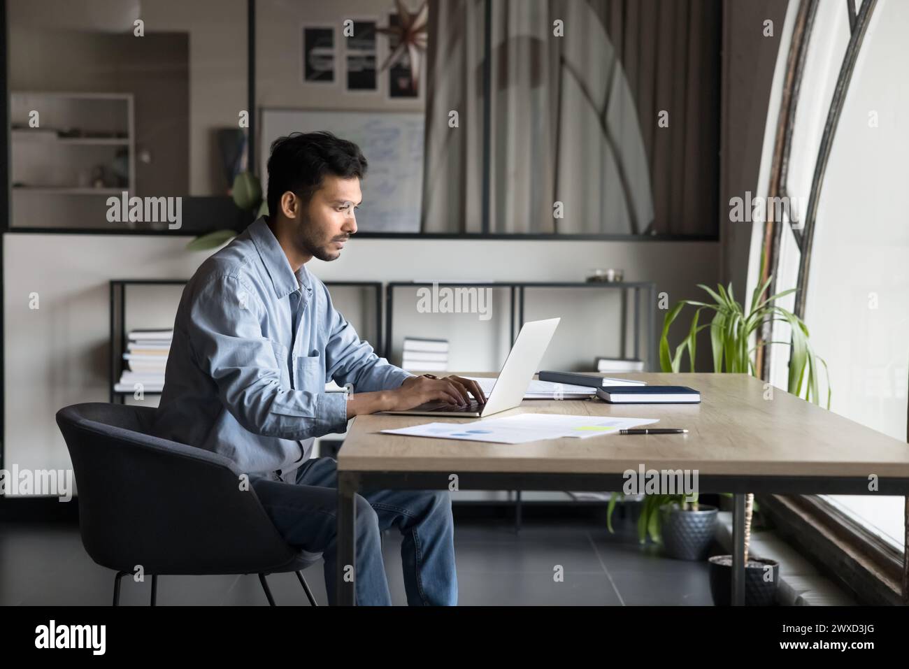Serious focused young Indian project manager man typing on laptop Stock Photo