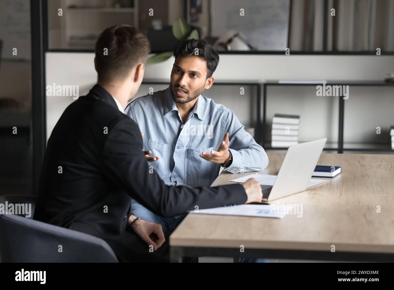 Serious focused young Indian businessman discussing job task plan Stock Photo