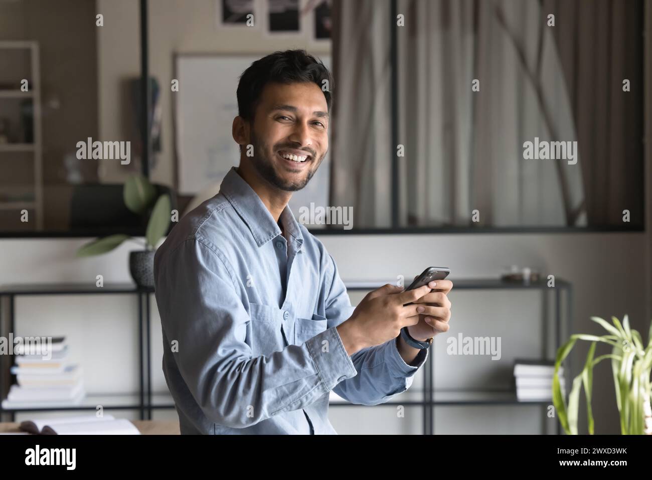 Cheerful successful Indian business professional man using financial application Stock Photo