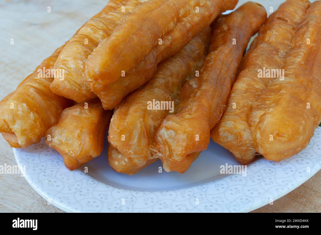 Close up of cakoi or youtiao cake on white plate. Asian food concept. Stock Photo