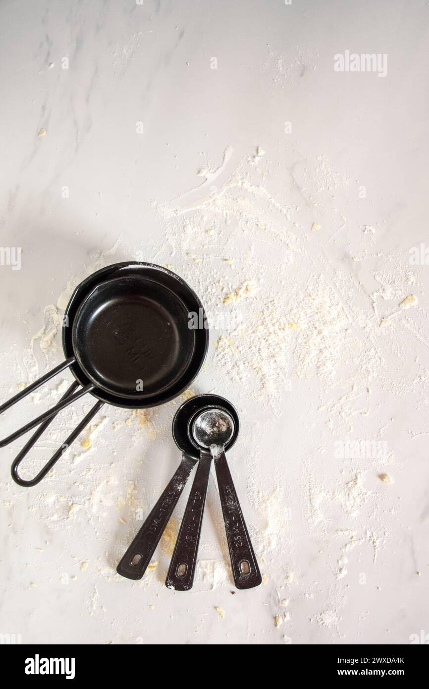 Various kitchen tools and two pans on flour surface Stock Photo