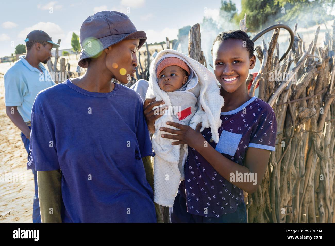 african family with one baby in the village in front of the outdoors kitchen smoke in the background Stock Photo