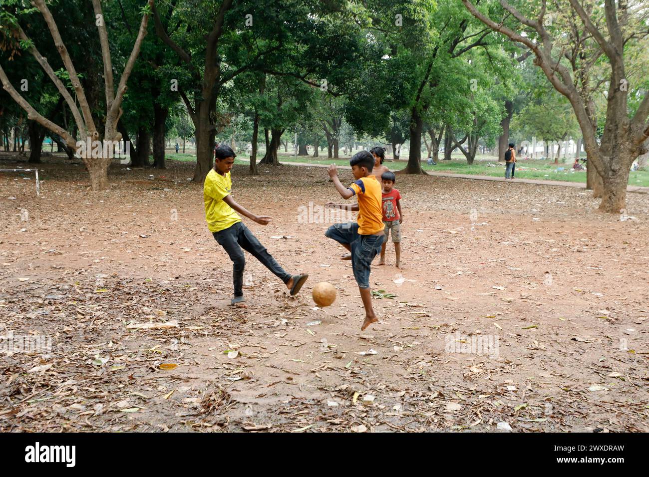 Dhaka, Bangladesh - March 30, 2024: Street children are playing football at Suhrawardy Udyan in Dhaka, Bangladesh. Stock Photo