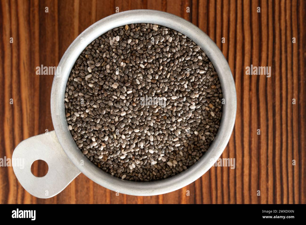 Black Chia Seeds in a Vintage Measuring Cup Stock Photo