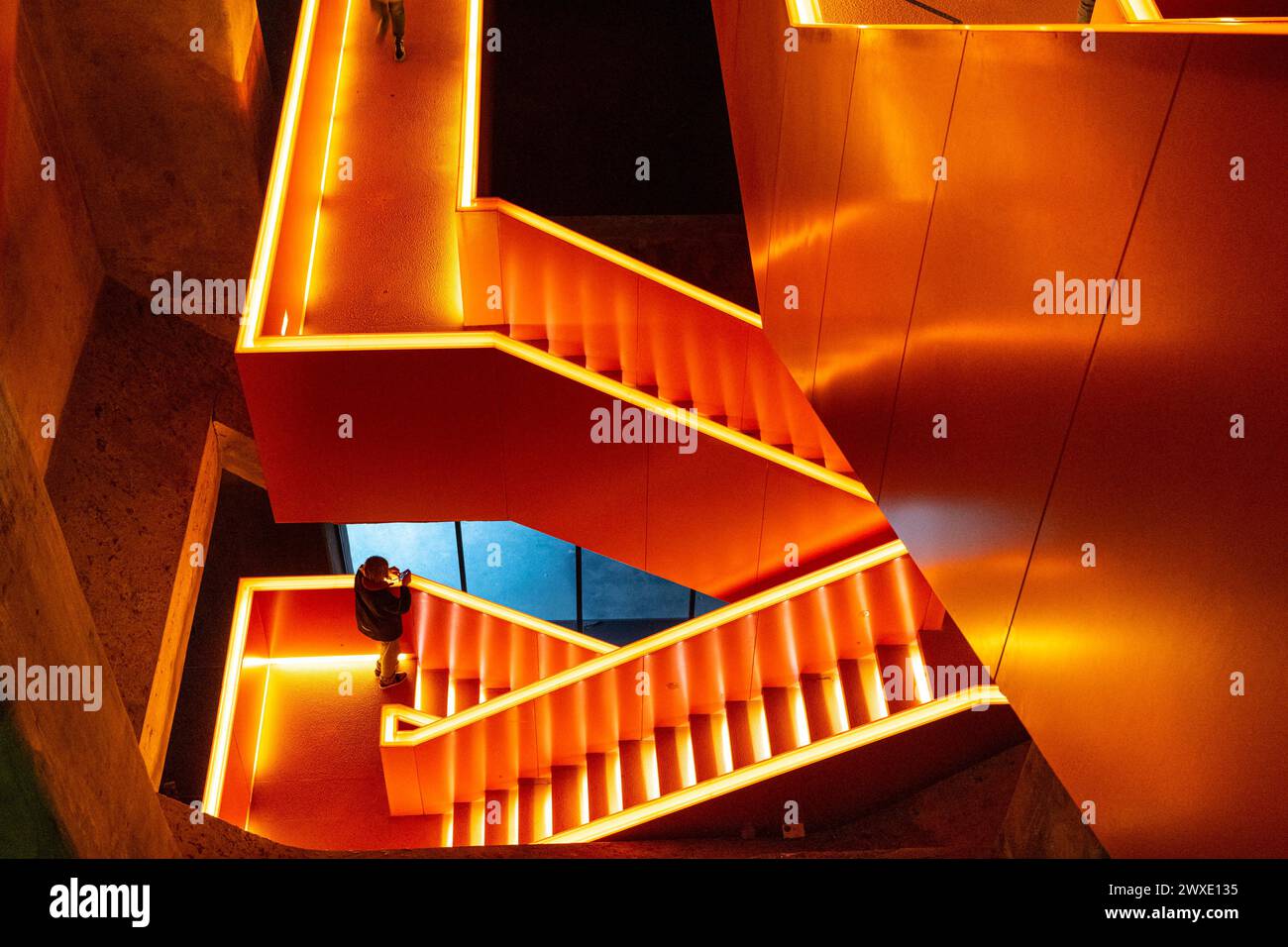 The orange illuminated staircase at Zeche Zollverein industrial monument and Ruhrmuseum, interior, Ruhr Area, Essen, Germany Stock Photo
