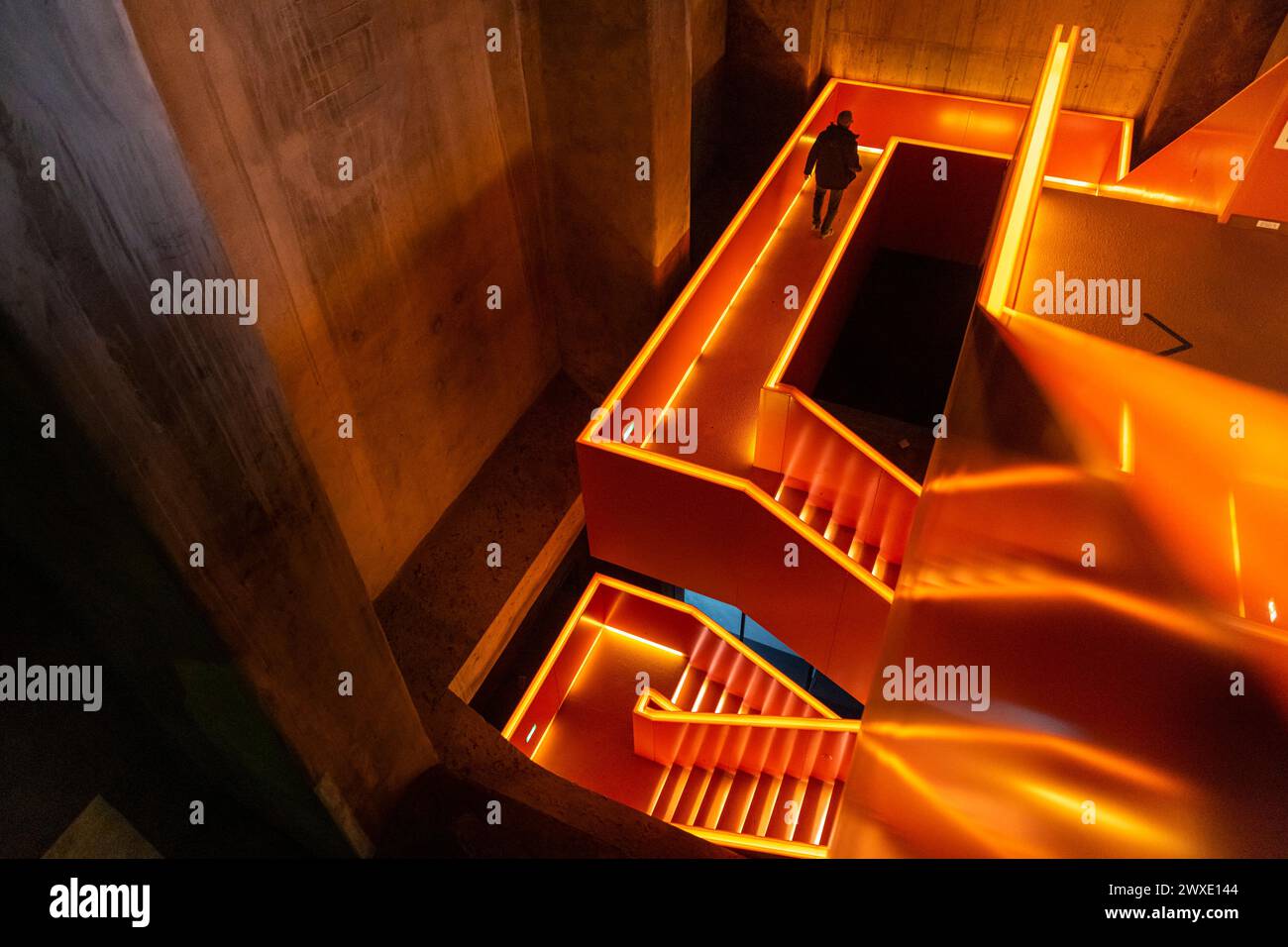 The orange illuminated staircase at Zeche Zollverein industrial monument and Ruhrmuseum, interior, Ruhr Area, Essen, Germany Stock Photo