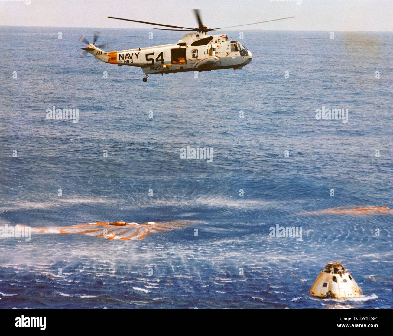 Immediately after splashdown a recovery helicopter from the USS Guadalcanal hovers over the Apollo 9 spacecraft. Still inside the Command Module (CM) are astronauts James A. McDivitt, David R. Scott, and Russell L. Schweickart. Splashdown occurred at 12:00:53 p.m. (EST), 13 March 1969. only 4.5 nautical miles from the USS Guadalcanal, the prime recovery ship, to conclude a successful 10-day Earth-orbital mission in space.  An optimised and enhanced version of an original NASA image / mandatory credit: NASA Stock Photo