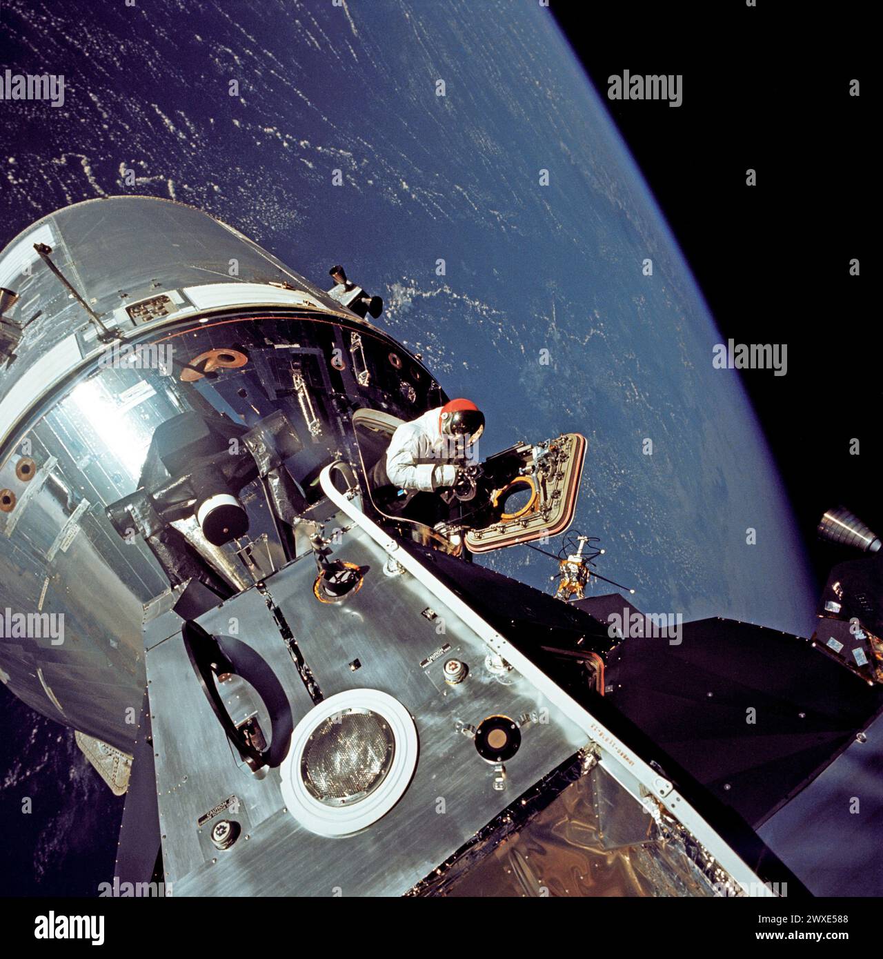 Apollo 9 Astronaut David Scott's Spacewalk view of the docked Apollo 9 command and service modules (CSM) and lunar module (LM), with Earth in the background, during astronaut David R. Scott's stand-up spacewalk, on the fourth day of the Apollo 9 Earth-orbital mission. Scott, command module pilot, is standing in the open hatch of the command module. Astronaut Russell L. Schweickart, lunar module pilot, took this photograph of Scott from the porch of the LM.3 March 3, 1969  An optimised and enhanced version of an original  NASA image / mandatory credit: NASA/RL Schweickart Stock Photo