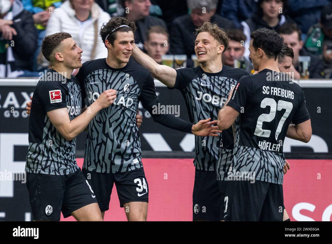 30 March 2024, North Rhine-Westphalia, Mönchengladbach: Soccer: Bundesliga, Bor. Mönchengladbach - SC Freiburg, Matchday 27, Stadion im Borussia-Park: Freiburg's Maximilian Eggestein (l-r), Merlin Röhl, Yannik Keitel and Nicolas Höfler celebrate after the 0:2 goal. Photo: David Inderlied/dpa - IMPORTANT NOTE: In accordance with the regulations of the DFL German Football League and the DFB German Football Association, it is prohibited to utilize or have utilized photographs taken in the stadium and/or of the match in the form of sequential images and/or video-like photo series. Stock Photo