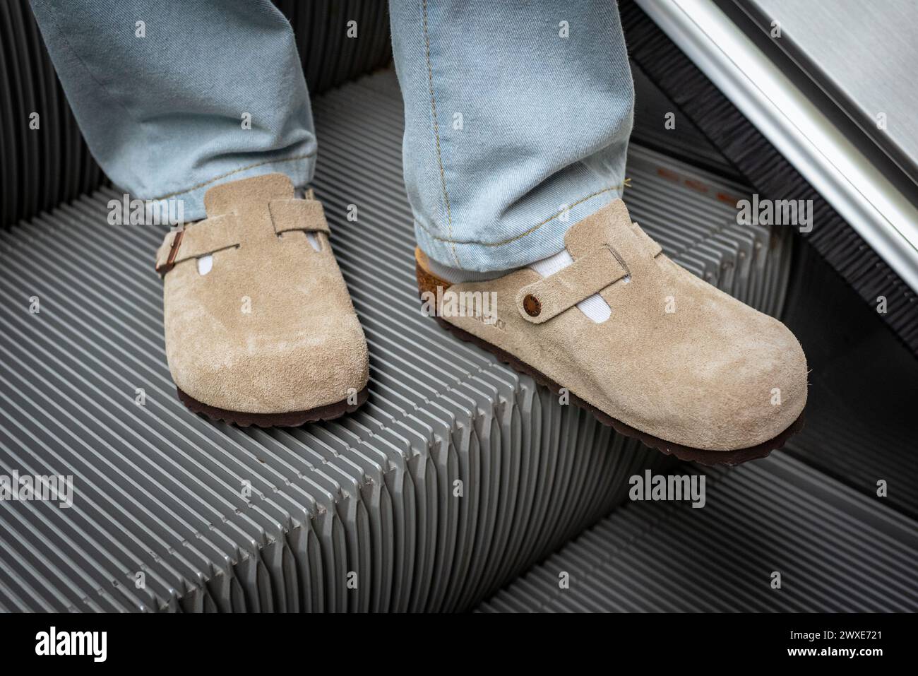 Close-up of man's feet in beige Birkenstock Boston on escalator on March 16, 2024, in Bangkok, Thailand. Stock Photo