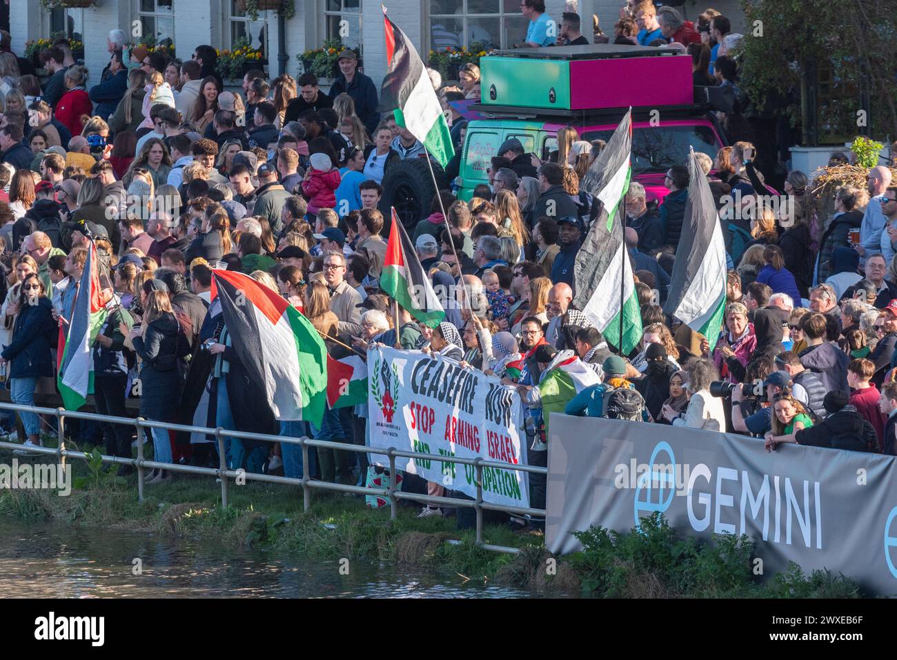 Chiswick Bridge, Chiswick, London, UK. 30th Mar, 2024. The finish line of the University Boat Race is just before Chiswick Bridge on the River Thames. Pro Palestine protesters were among the crowds at the finish Stock Photo