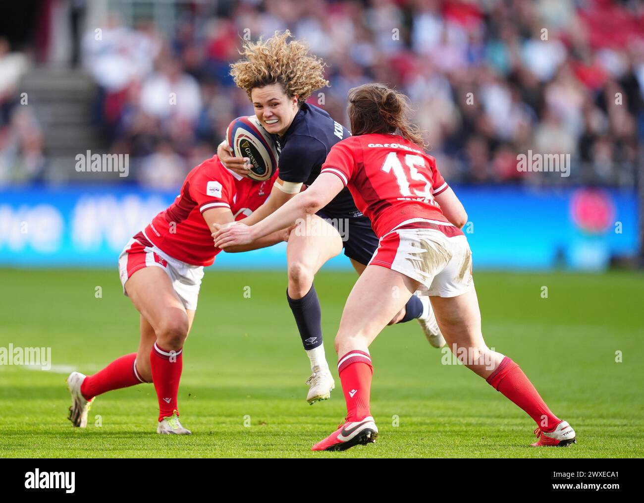 England's Ellie Kildunne is tackled by Wales's Hannah Jones (left) and Wales's Jenny Hesketh (right) during the Guinness Women's Six Nations match at Ashton Gate, Bristol. Picture date: Saturday March 30, 2024. Stock Photo