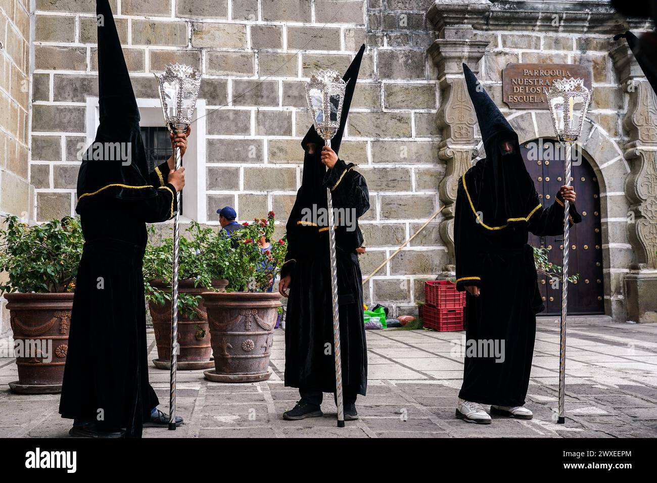 Antigua, Guatemala. 29th Mar, 2024. A confraternity of penitents, wearing capirote hats, wait outside the Escuela de Cristo church for the start of the Senor Sepultado Good Friday procession during Semana Santa, March 29, 2024 in Antigua, Guatemala. The opulent procession is one of the largest in the world involving thousands of devotees and lasting 12-hours. Credit: Richard Ellis/Richard Ellis/Alamy Live News Stock Photo