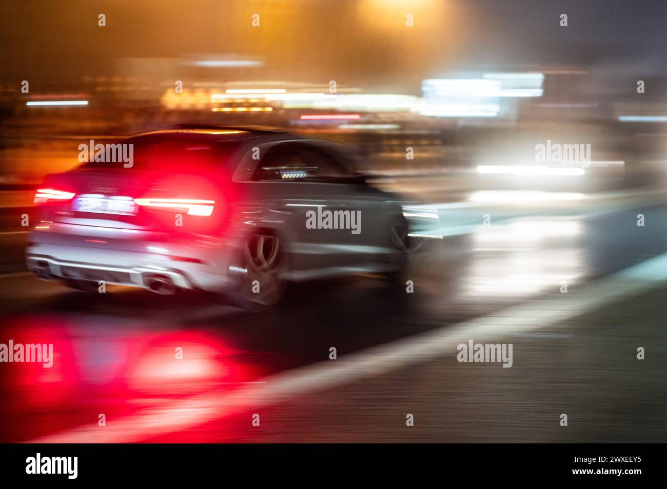 Ein Auto fährt am so genannten Carfreitag am Nürburgring bei Dunkelheit auf einer Straße. Der Carfreitag ist der Saisonauftakt der Autofans. Nürburg Rheinland-Pfalz Deutschland *** A car drives on a road in the dark on what is known as Car Friday at the Nürburgring Car Friday is the season opener for car fans Nürburg Rhineland-Palatinate Germany Stock Photo