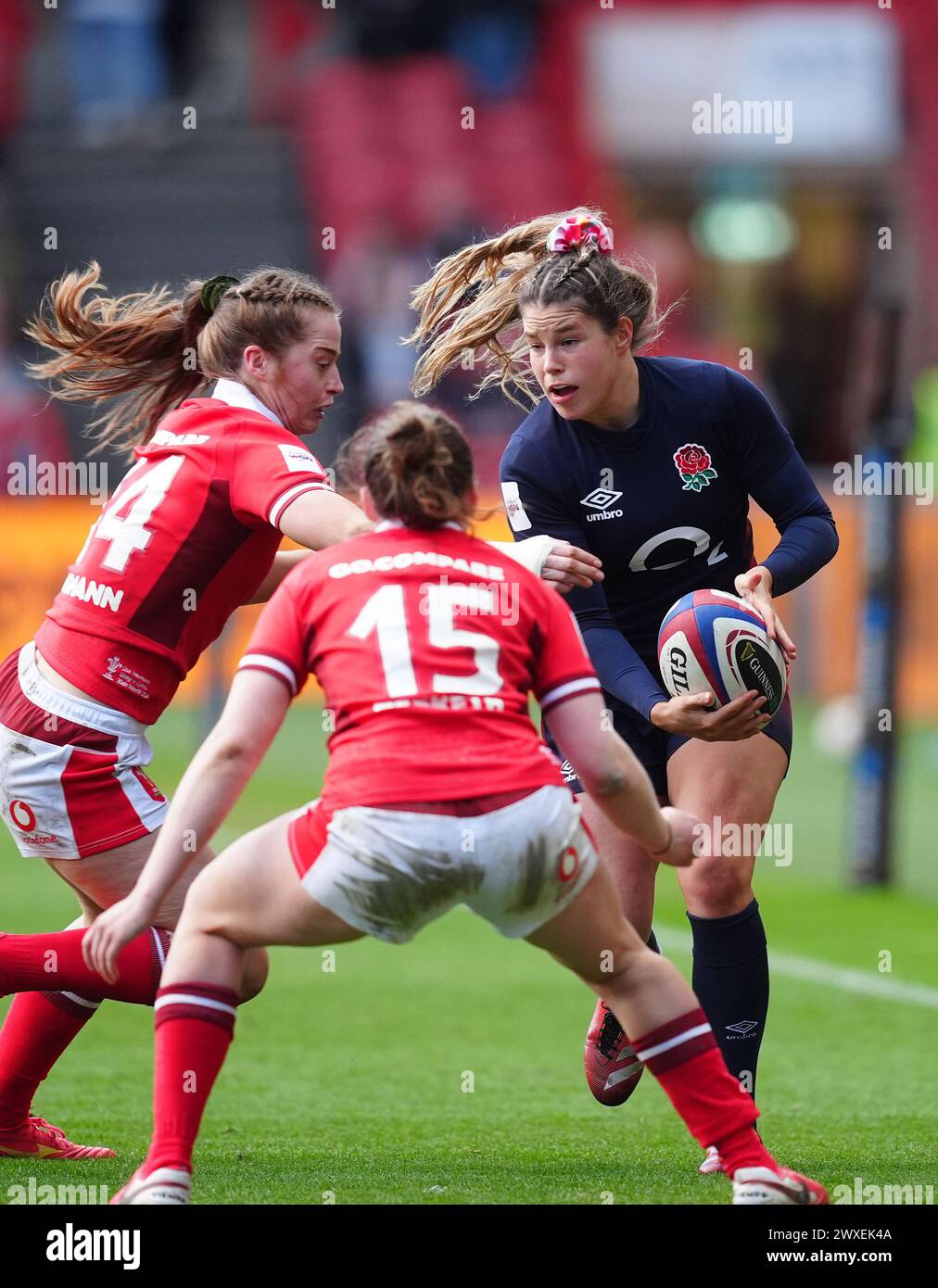 England's Jess Breach (right) is tackled by Wales's Lisa Neumann (left) and Wales's Jenny Hesketh (centre) during the Guinness Women's Six Nations match at Ashton Gate, Bristol. Picture date: Saturday March 30, 2024. Stock Photo