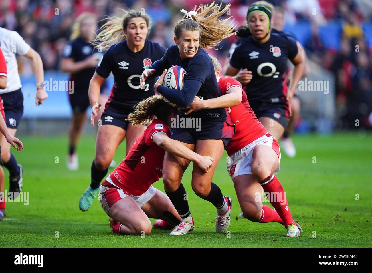 England's Zoe Harrison (centre) is tackled by Wales' Carys Cox and Hannah Jones during the Guinness Women's Six Nations match at Ashton Gate, Bristol. Picture date: Saturday March 30, 2024. Stock Photo