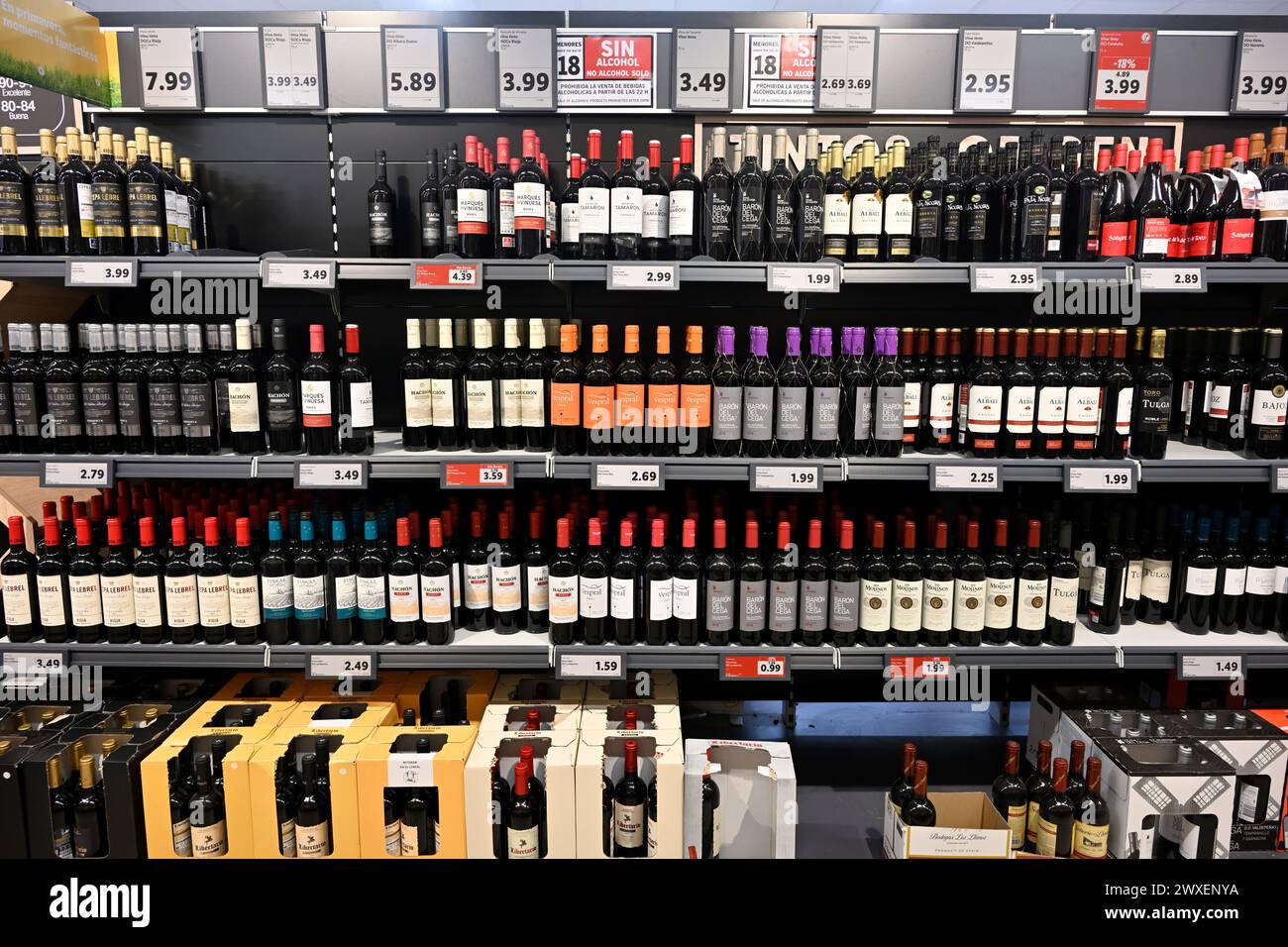 Shelves full of wine bottles in Lidl supermarket with prices, Spain Stock Photo