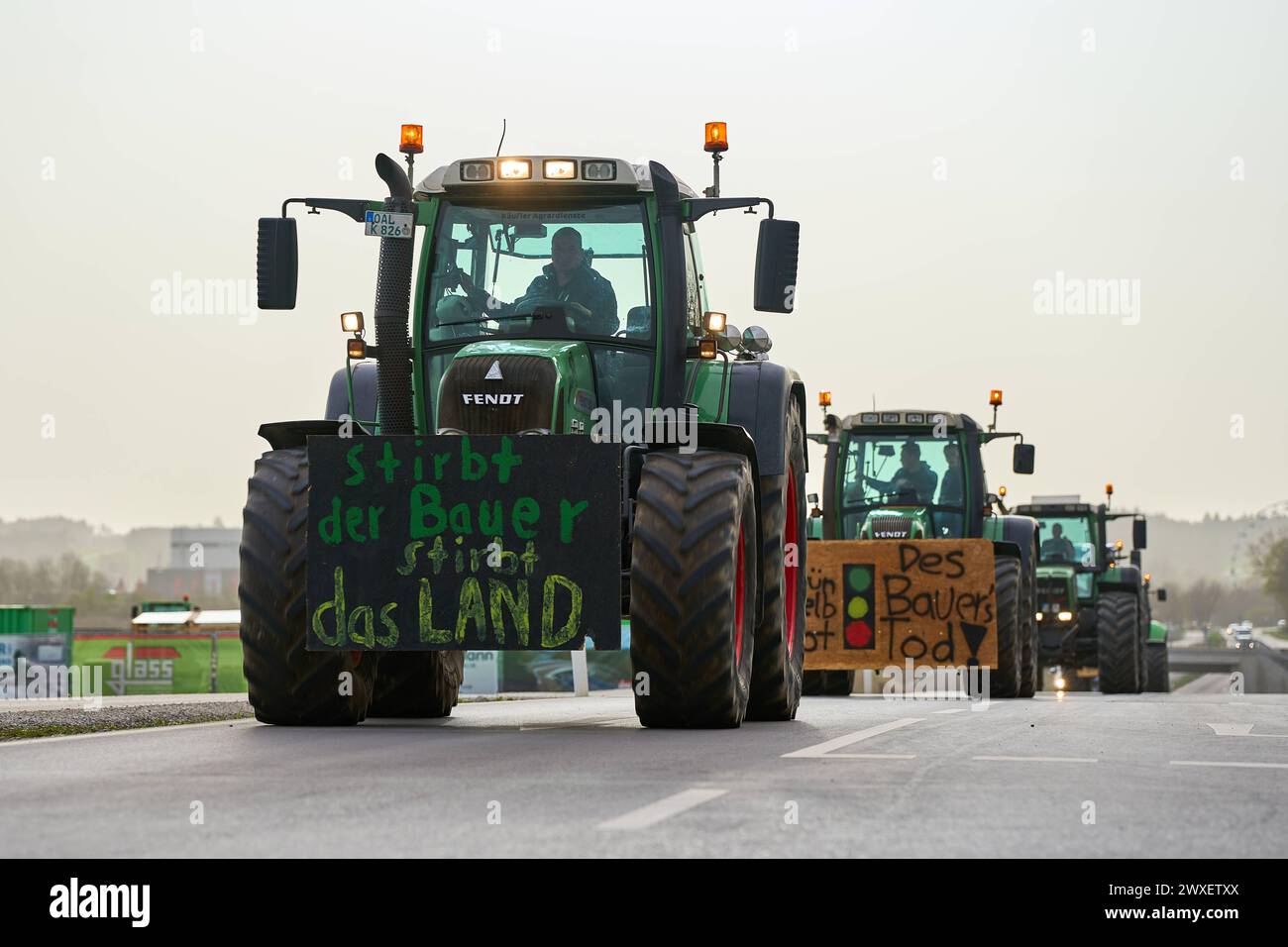 Türkheim / Bad Wörishofen, Bavaria, Germany - March 30, 2024: Easter weekend demonstration of tractors and cars against the traffic light government s policy. Posters on tractors and vehicles on the country road in Unterallgäu between Türkheim and Bad Wörishofen *** Demonstrationszug am Osterwochenende aus Traktoren und Autos gegen die Politik der Ampel-Regierung. Plakate an Traktoren und Fahrzeugen auf der Landstraße im Unterallgäu zwischen Türkheim und Bad Wörishofen Stock Photo