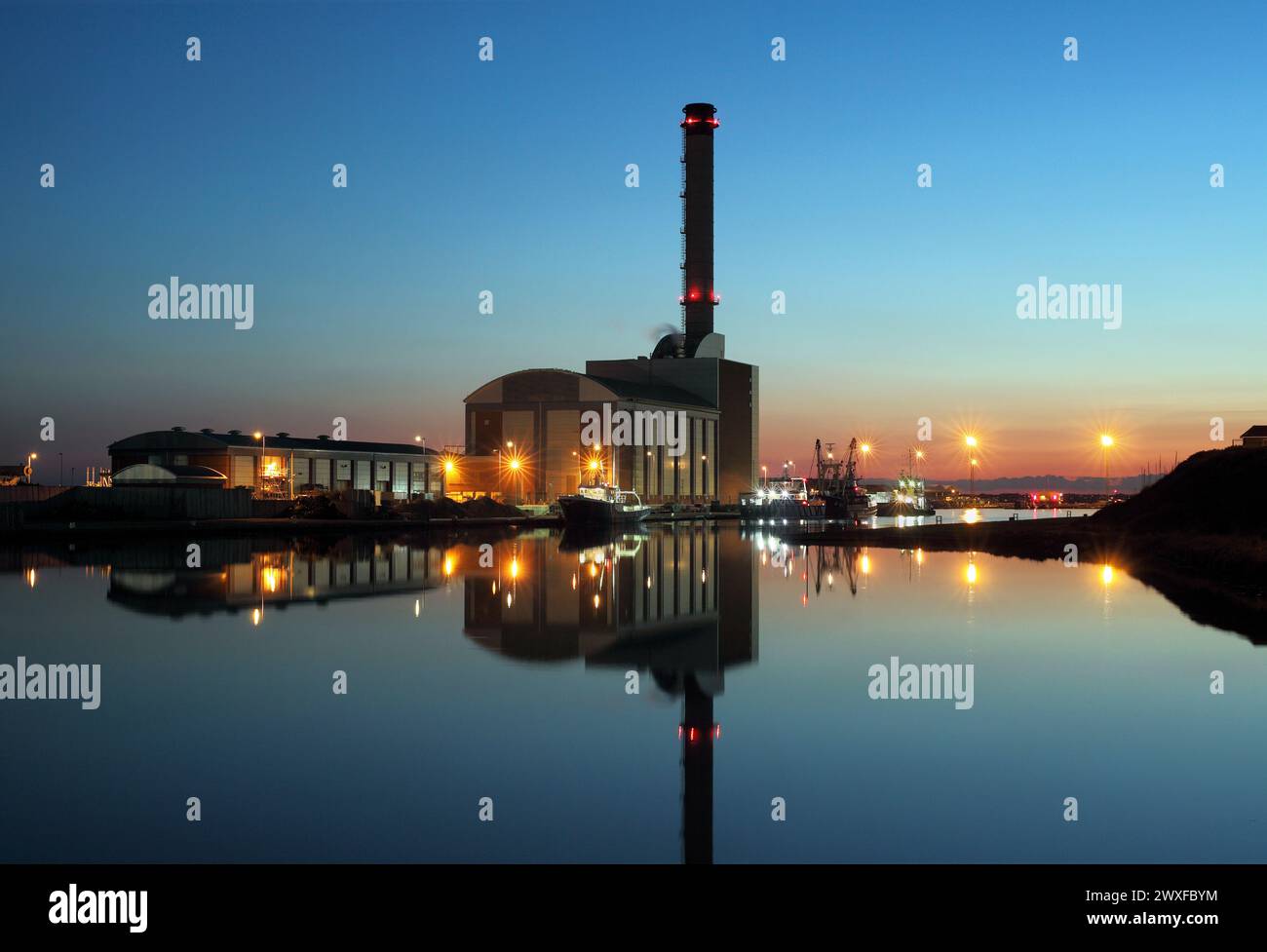 A twilight view of Shoreham gas-fired power station and its reflection in   the still waters of Shoreham Harbour. Stock Photo