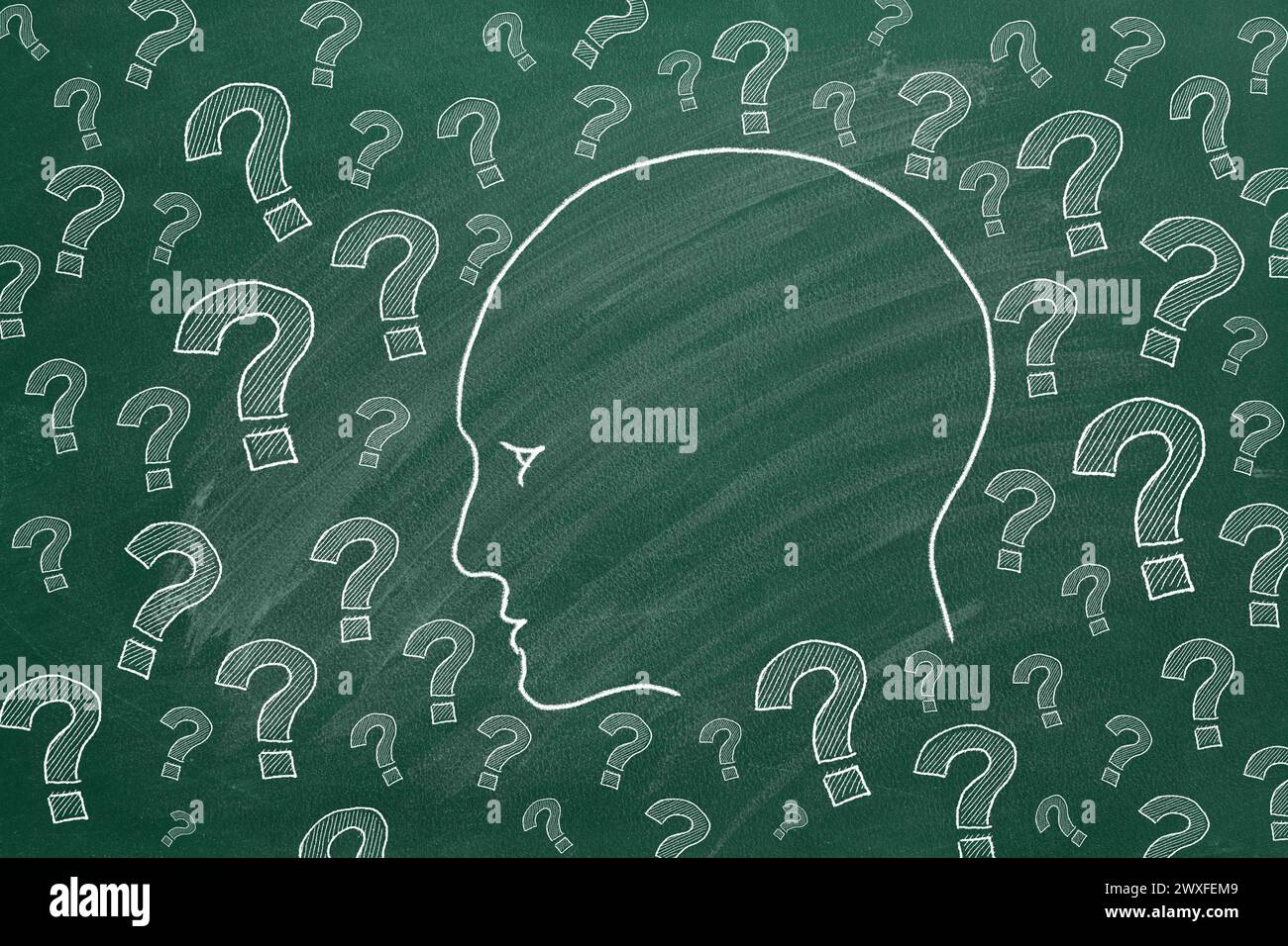 Human head with question marks. Illustration on greenboard. Stock Photo