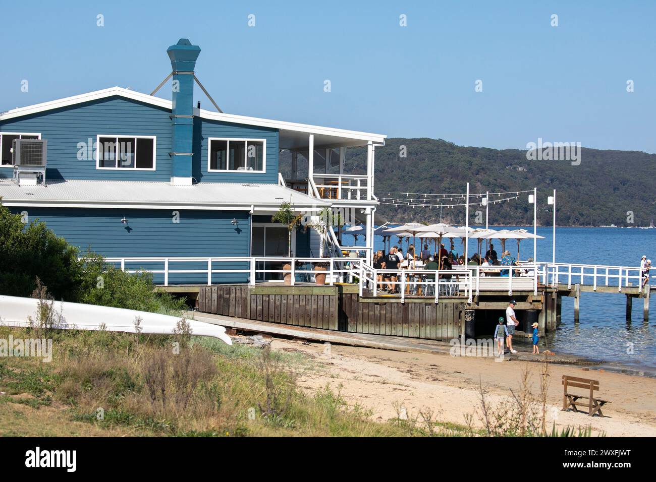 The Joey, waterfront restaurant and cafe, people sitting on timber deck enjoying lunch overlooking Pittwater, Palm Beach in Sydney,Australia,2024 Stock Photo