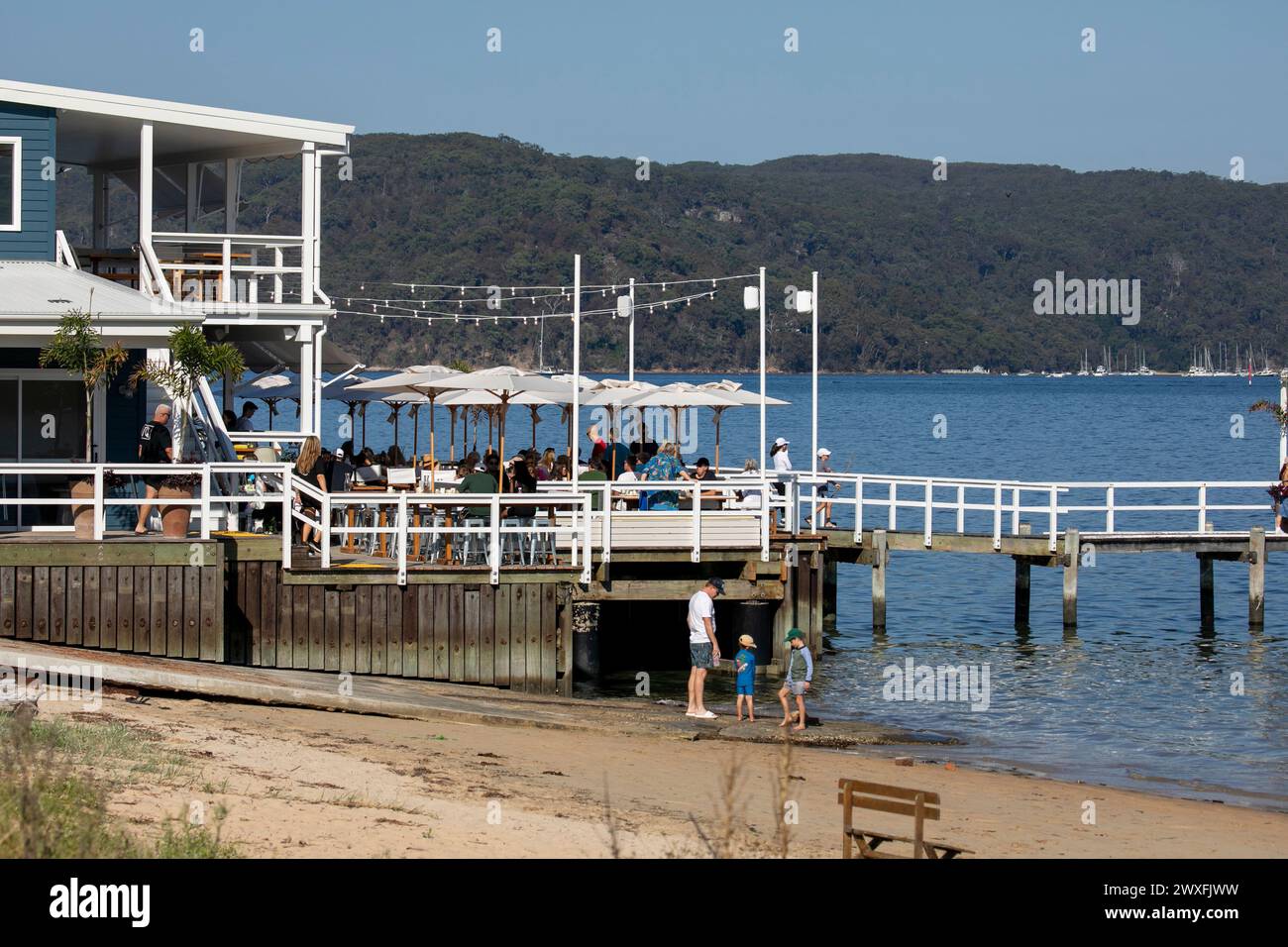 The Joey, waterfront restaurant and cafe, people sitting on timber deck enjoying lunch overlooking Pittwater, Palm Beach in Sydney,Australia,2024 Stock Photo