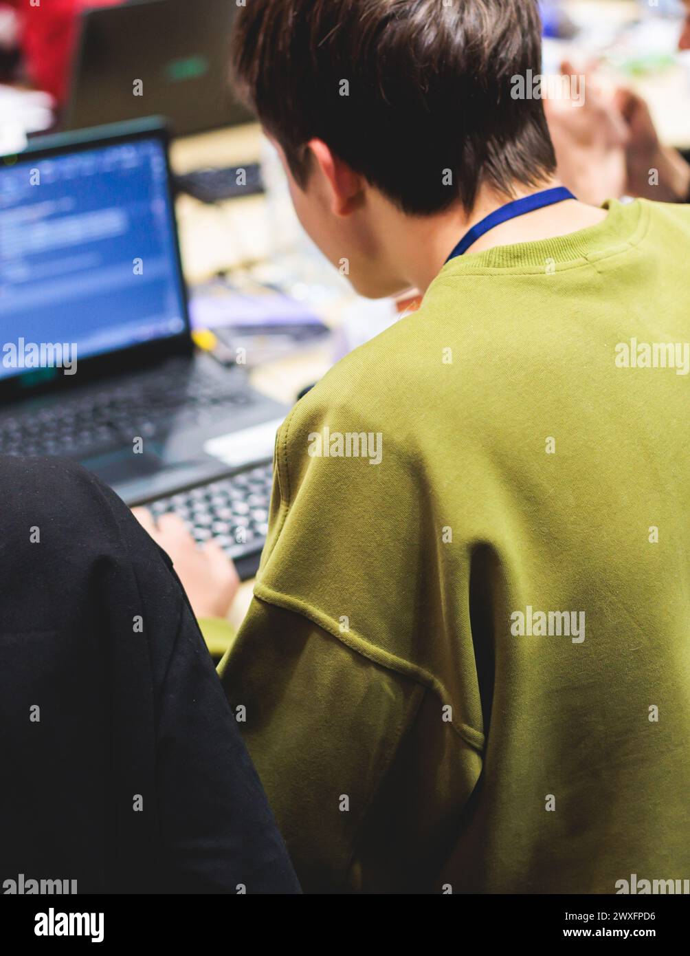 Software developer students in auditorium hall working on computer and ...