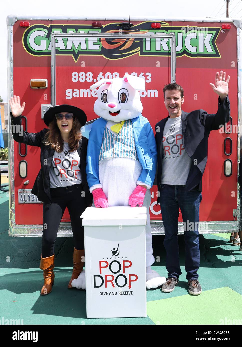 Woodland Hills, California, USA. 30th March, 2024. Niki Shadrow Snyder (R) and John David Snyder (L), founders of Project Pop Drop, take a photo with the Easter Bunny at Project Pop Drop's Charity Easter Egg Hunt for Hope The Mission in Woodland Hills, California. Credit: Sheri Determan Stock Photo