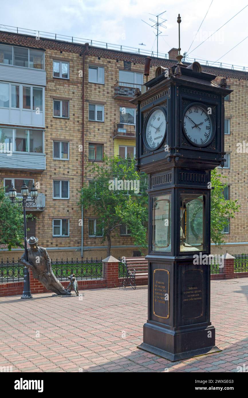 Krasnoyarsk, Russia - July 23 2018: Hourglass (Russian: Песочно-паровые часы) with behind the sculpture of Uncle Vasya - A Drunkard (Russian: Дядя Вас Stock Photo