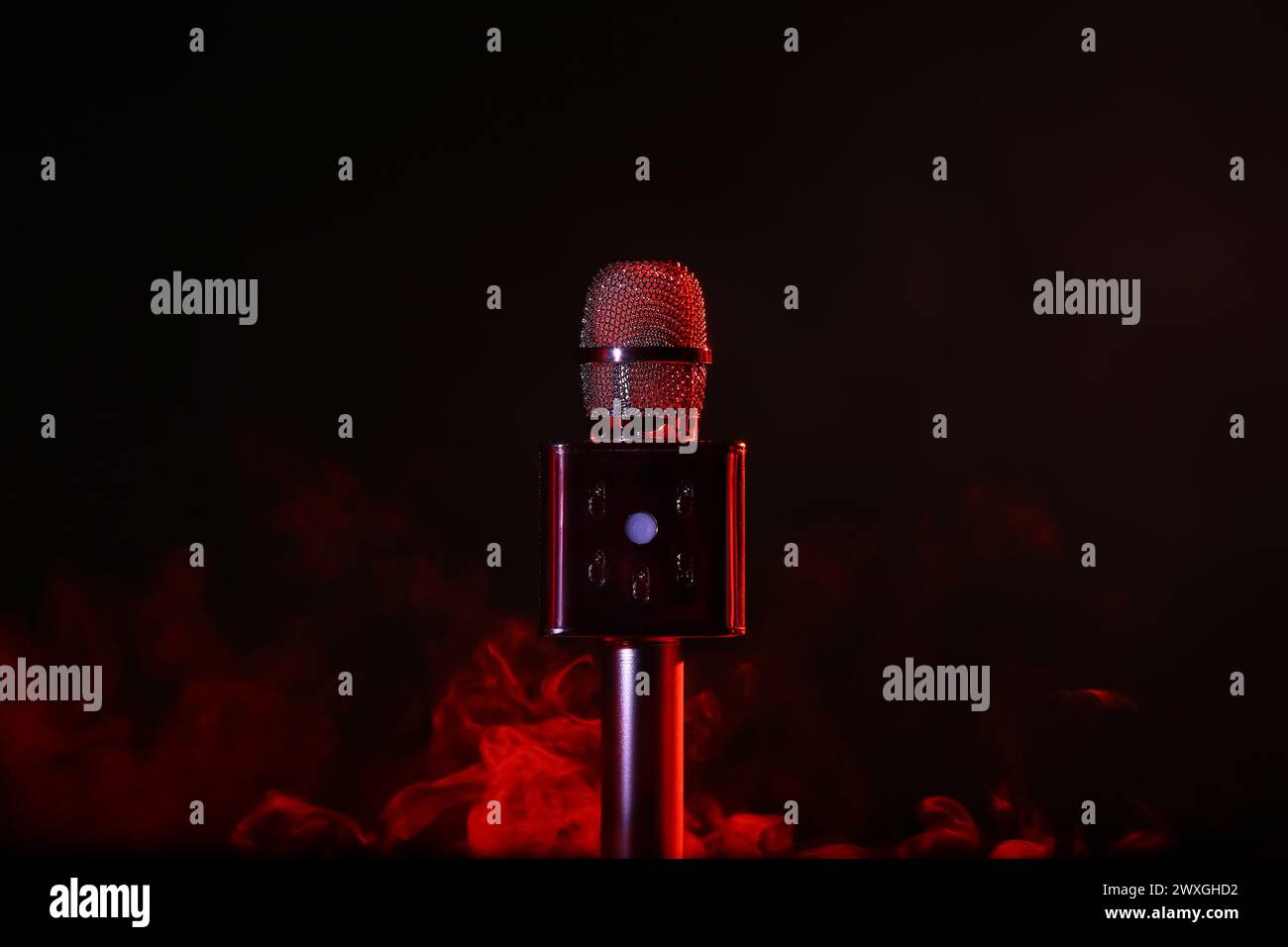 Modern microphone and red smoke on dark background Stock Photo - Alamy