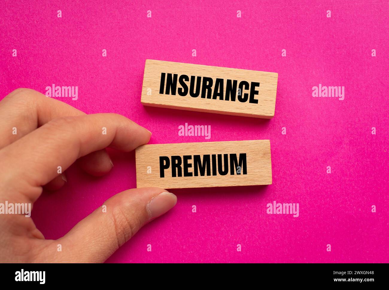 Insurance premium words written on wooden blocks with pink background. Conceptual symbol. Copy space. Stock Photo
