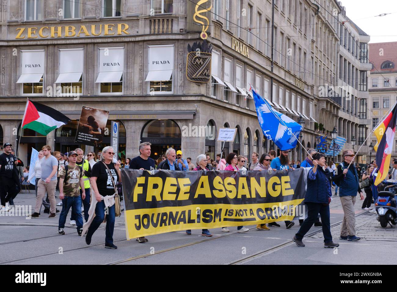30.03.2024 Demonstration Ostermarsch Free Assange 30.03.2024 Demonstranten ziehen mit Fahnen und Banner Free Assange durch die Münchner Innenstadt Mün Stock Photo
