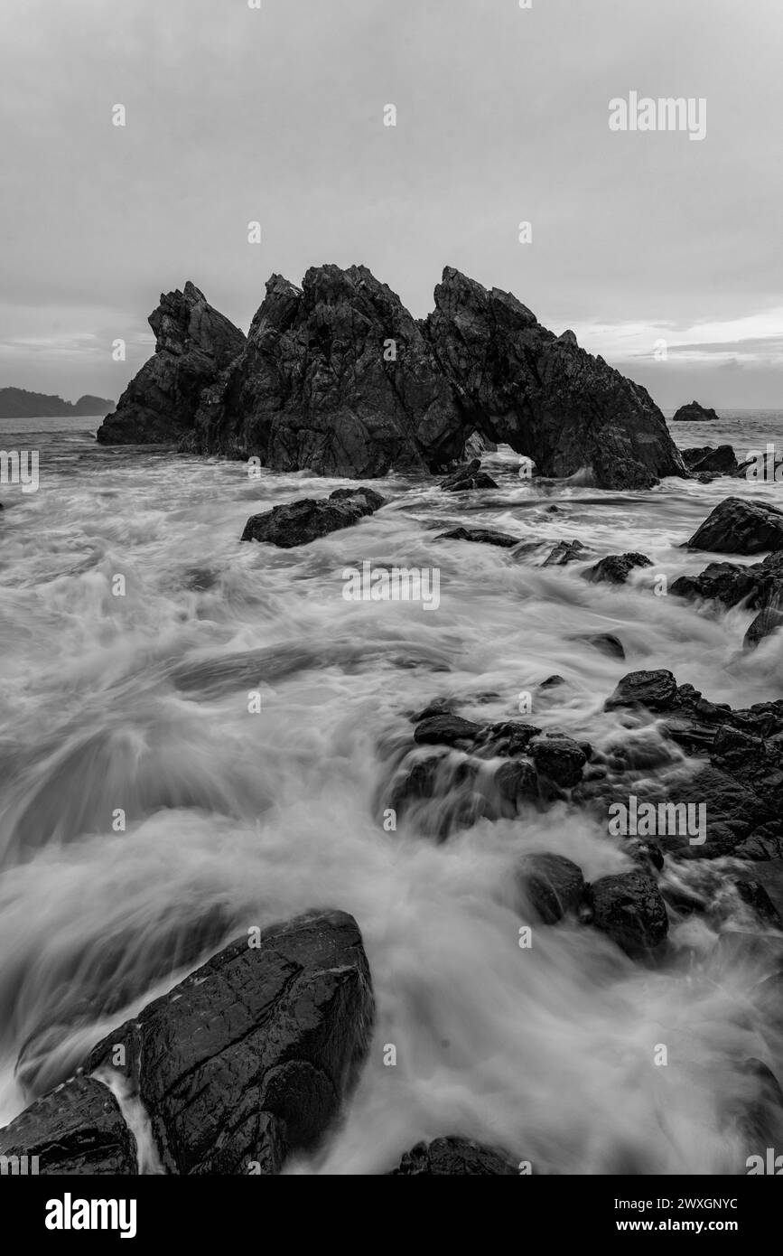 A scenic view of the seascape in Gigi Hiu Lampung, Indonesia in grayscale Stock Photo
