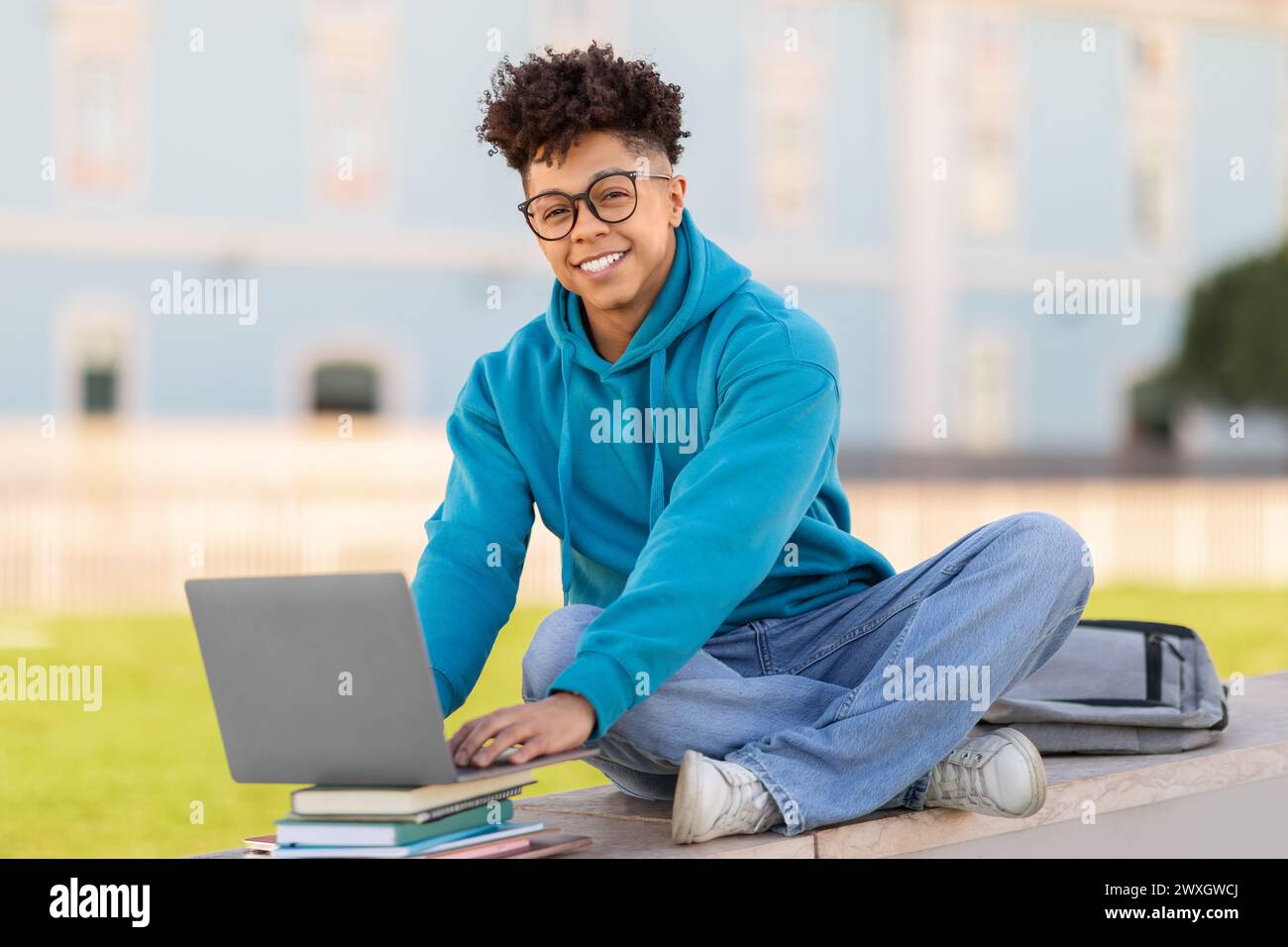 Happy student using laptop on university campus Stock Photo