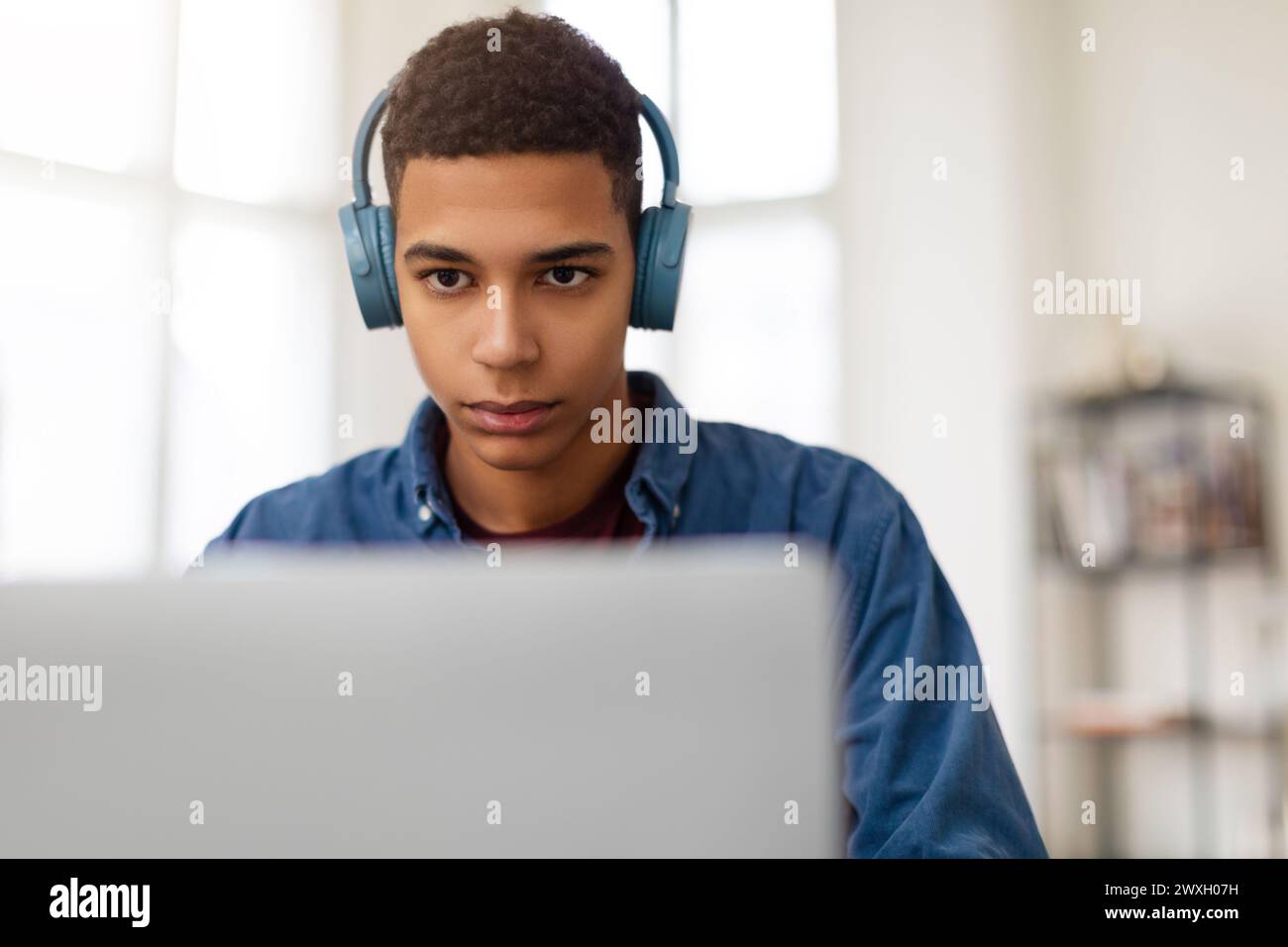Young man with headphones using laptop Stock Photo