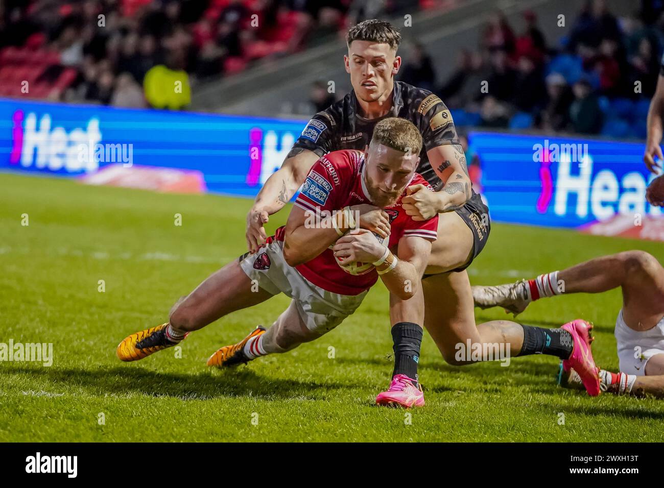 Salford, Manchester, UK. 30th March, 2024. Super League Rugby: Salford Red Devils Vs Leigh Leopards at Salford Community Stadium. ETHAN RYAN beating the Leigh defender to score. Credit James Giblin/Alamy Live News. Stock Photo