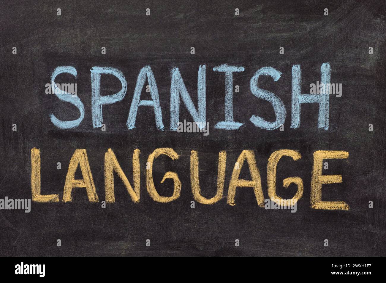 The words Spanish Language written in chalk on a blackboard. Stock Photo