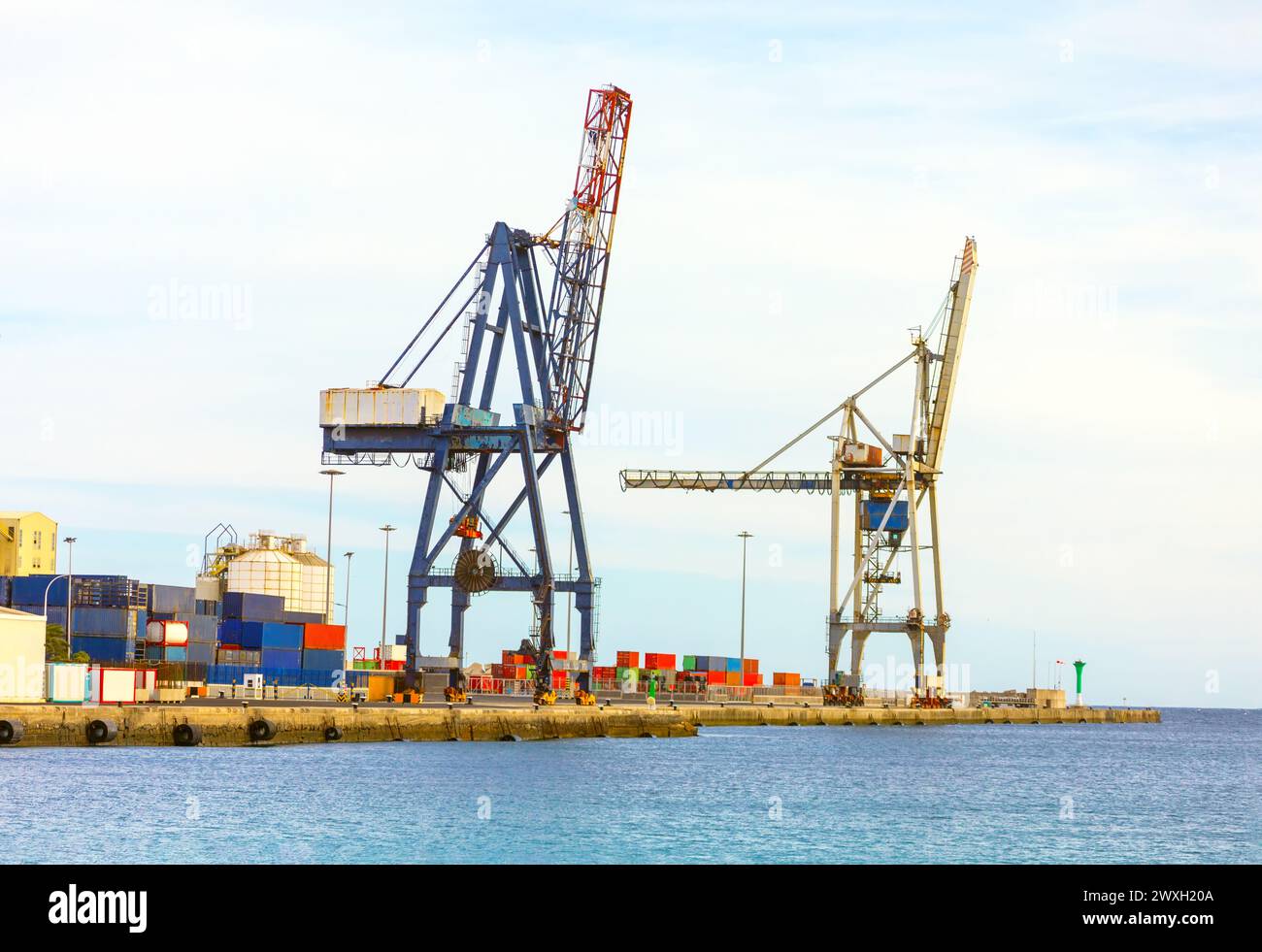 Port cargo crane and container ship in blue sky background, industrial ...